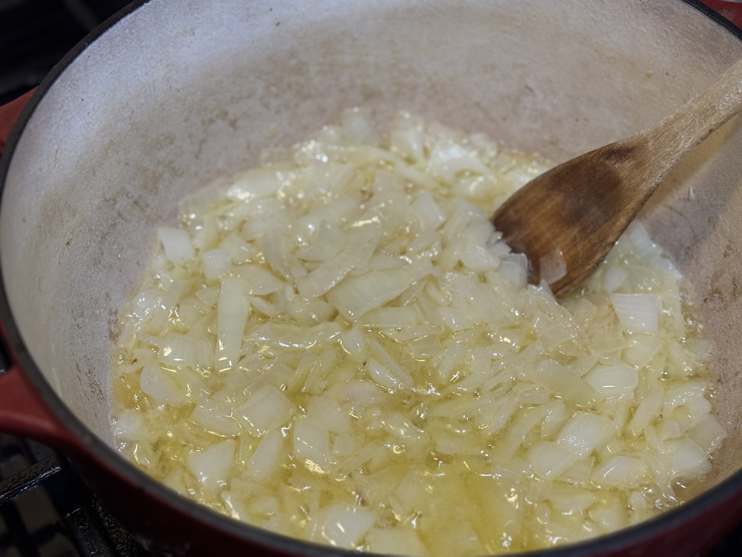 Diced onions sautéing in butter in a Dutch oven for homemade cream of mushroom soup
